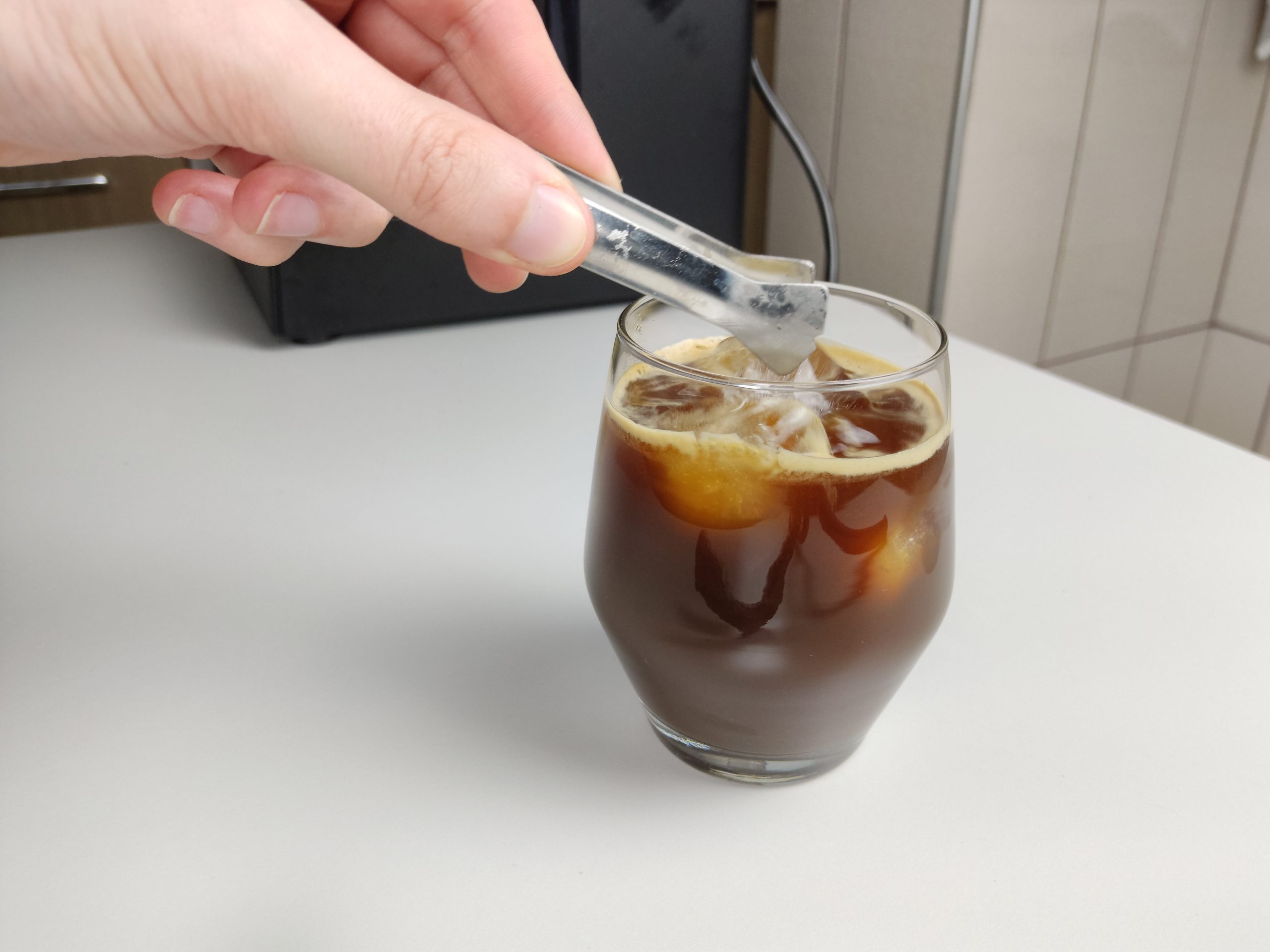 adding ice cubs to iced americano